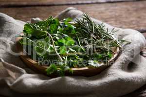 Fresh herbs in wooden plate