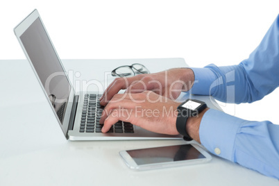 Cropped image of businessman working on laptop at table