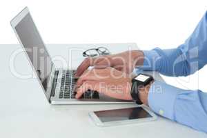 Cropped image of businessman working on laptop at table