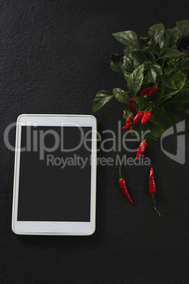 Digital tablet with red chili and leaves