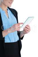 Mid section of smiling businesswoman wearing suit using glass interface