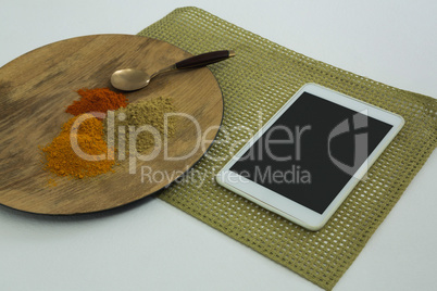 Various type of spices on wooden board with digital tablet