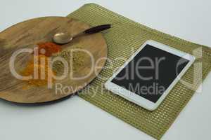Various type of spices on wooden board with digital tablet