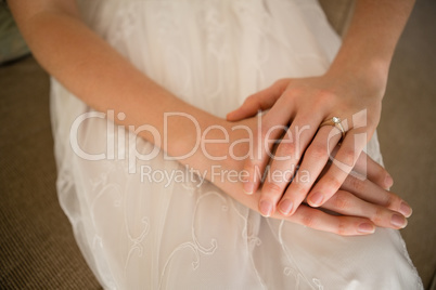Midsection of bride wearing wedding ring while sitting on sofa