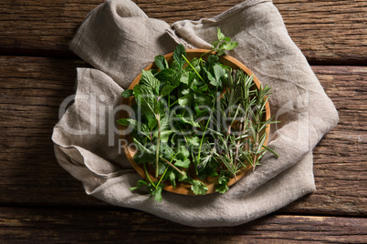 Fresh herbs in wooden plate