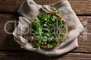 Fresh herbs in wooden plate