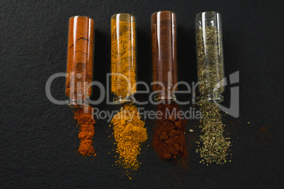 Various spices spilling out of bottles
