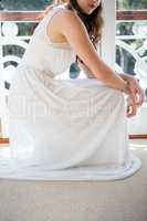 Low section of beautiful bride crouching by door