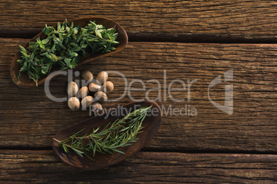 Nutmeg and rosemary herbs  on a wooden table