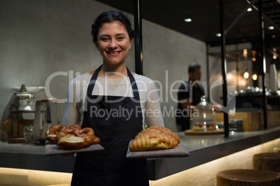 Portrait of happy waitress holding breakfast