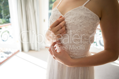 Midsection of bride trying on wedding dress