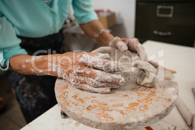 Mid section of man molding clay