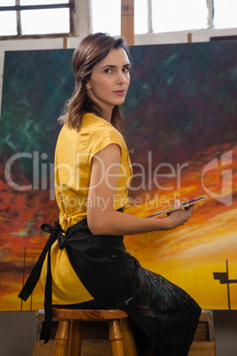 Woman painting on canvas in drawing class