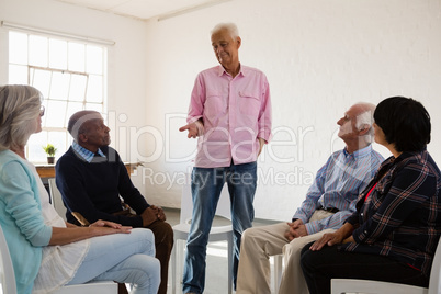 Man talking to friends sitting on chair