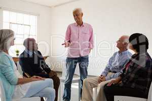 Man talking to friends sitting on chair