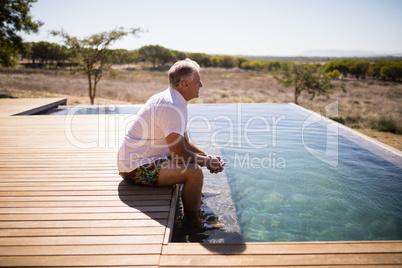 Thoughtful man sitting near pool side