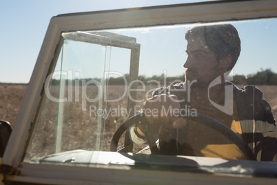 Man in off road vehicle seen through windshield