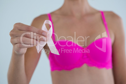 Mid section of woman showing Breast Cancer Awareness ribbon