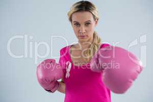 Portrait of young woman punching with boxing gloves