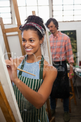 Man and woman painting on canvas