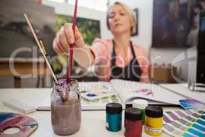 Woman selecting a paintbrush