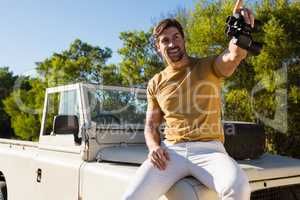 Man with binocular sitting on off road vehicle