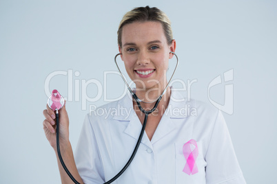 Doctor with stethoscope showing Breast Cancer Awareness ribbons