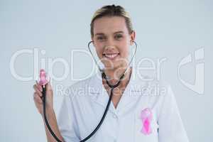Doctor with stethoscope showing Breast Cancer Awareness ribbons