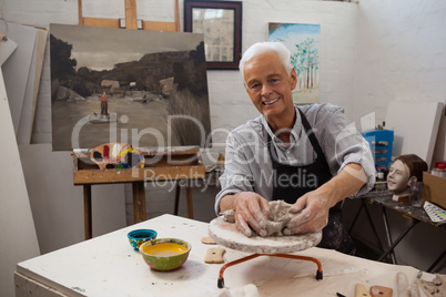 Portrait of senior man molding clay