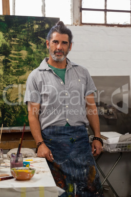 Portrait of confident man standing at table