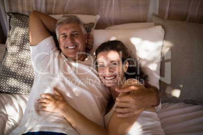 Happy couple relaxing in canopy bed
