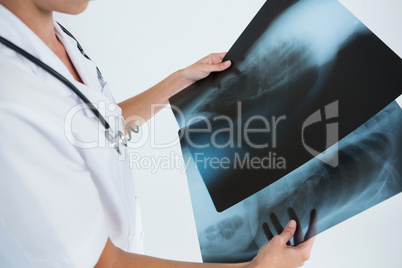 Mid section of female doctor examining X-rays
