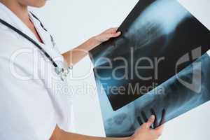 Mid section of female doctor examining X-rays