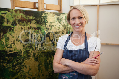 Portrait of smiling woman standing with arms crossed