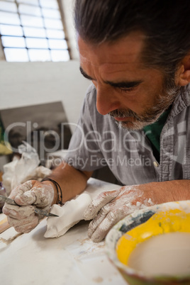 Close-up of attentive man molding sculpture