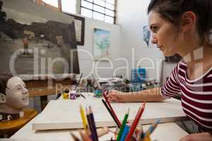 Woman sketching on canvas in drawing class