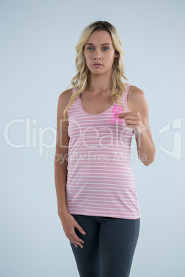 Portrait of young female holding pink ribbon