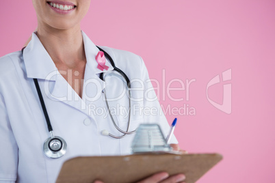 Mid section of smiling doctor with clipboard