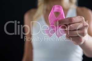 Mid section of woman showing pink ribbon