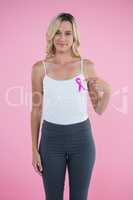 Portrait of young woman pointing on Breast Cancer Awareness ribbon