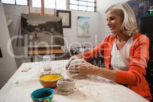 Attentive senior woman molding clay