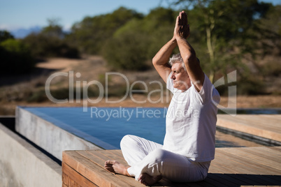 Man practicing yoga on wooden plank