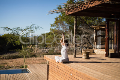 Woman practicing yoga on wooden plank