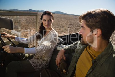 Woman looking at man in off road vehicle