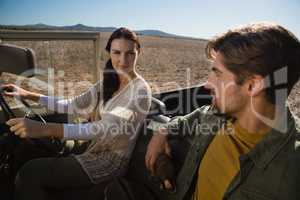 Woman looking at man in off road vehicle