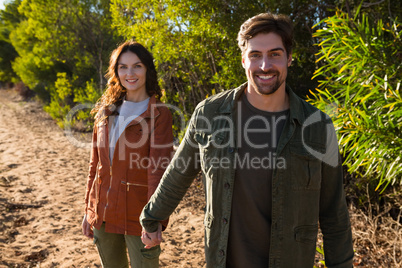 Portrait of couple holding hands on field