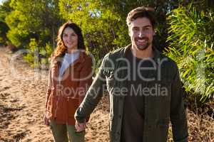 Portrait of couple holding hands on field