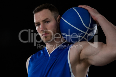 Portrait of confident player holding basketball