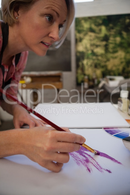 Woman painting in drawing book