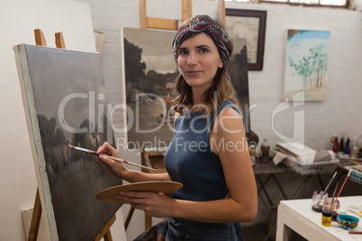 Woman painting on canvas in drawing class